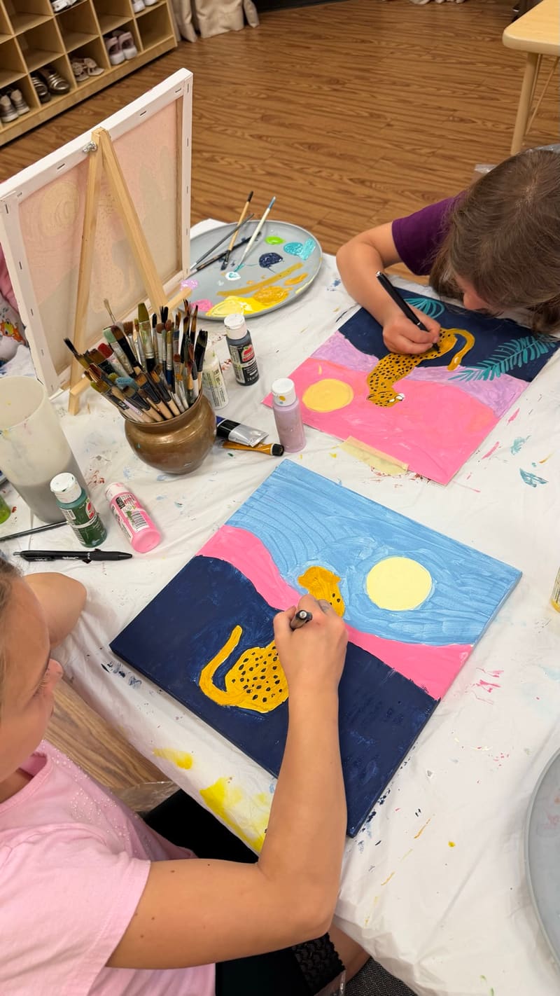 Students painting bright leopard artwork
