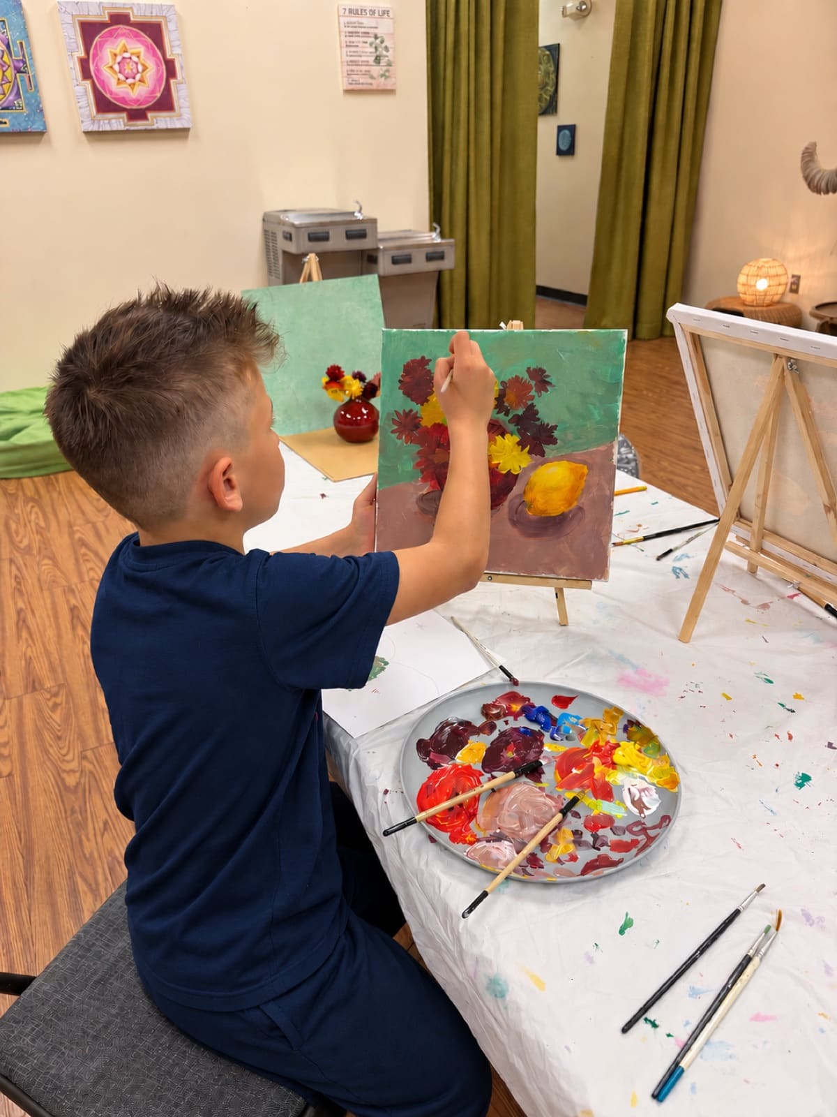Young student painting a blue landscape during art class